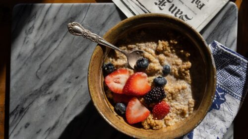 a bowl of oatmeal with strawberries and blueberries