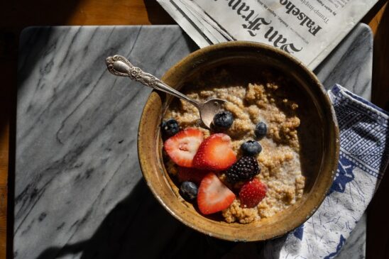 a bowl of oatmeal with strawberries and blueberries
