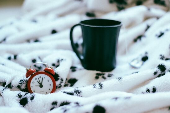 FITPULSE | The Importance of a Morning Routine green ceramic mug near analog alarm clock