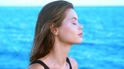 a woman standing in front of a body of water