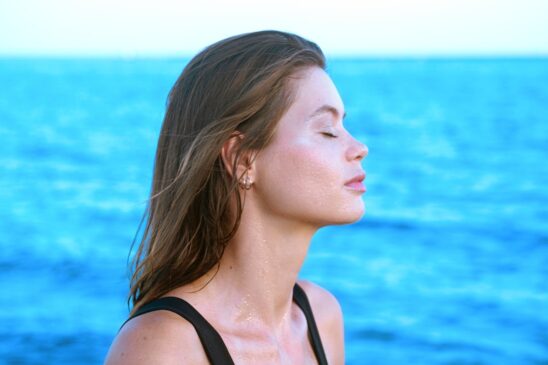 a woman standing in front of a body of water